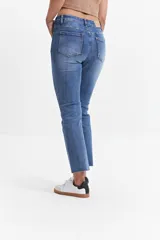 Jean straight de tiro medio, color azul denim, con corte recto y ruedo desflecado.