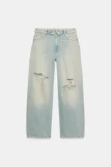 Jeans de tiro medio y pernera recta de corte holgado en tono celeste claro con efecto desteñido y roturas en las rodillas. Presenta diseño de doble cinturilla y estilo clásico de cinco bolsillos.