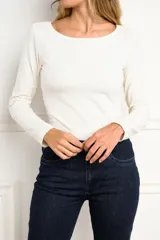 Remera de manga larga en color crudo, con cuello bote y corte ajustado al cuerpo.