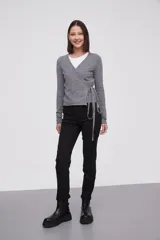 Saco tipo cardigan cruzado de punto, color gris melange, con escote en V profundo, mangas largas y lazo lateral para ajustar a la cintura.