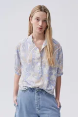 Blusa estampada con botones en el frente y mangas tres cuartos.