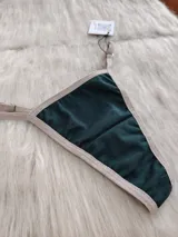 Microtanga de algodón en color verde oscuro con bordes y elásticos en tono beige.
