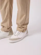Pantalón de corte recto en color beige, confeccionado en mezcla de algodón y lino, con bolsillos laterales y trabillas para cinturón.