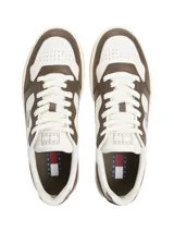 Zapatillas deportivas de corte bajo, color block blanco y marrón oscuro, con cordones. Presentan una suela cupsole de goma color crema y marrón claro, y un parche con el logo de Tommy Jeans en el lateral.