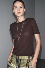 Top de manga corta color beige claro, con cuello redondo y textura de tejido de punto fino.