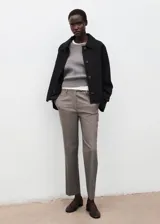Pantalón de vestir color gris con sutil patrón a cuadros, de corte recto y tiro medio con bolsillos laterales.