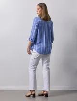 Camisa de lino marca Dash, color beige con rayas verticales blancas, cuello con solapa, cierre frontal de botones, bolsillo aplicado en el pecho y mangas largas con sistema para arremangar mediante presilla y botón.