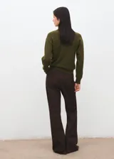 Jersey de punto verde militar con cuello polo y cierre frontal parcial con botones. Presenta manga larga y diseño de corte recto.