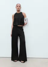 Pantalón largo negro de corte recto y tiro medio, con cintura elástica y bolsillos laterales. Confeccionado en tejido de punto fino con mezcla de viscosa.