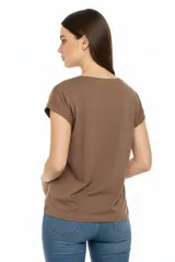 Remera de algodón color beige con cuello redondo y mangas cortas con dobladillo. Presenta un estampado frontal con diseño botánico y texto en tonos marrones.