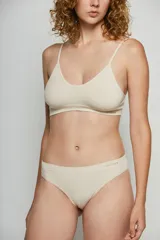 Top de estilo deportivo confeccionado en tejido seamless, con breteles finos y escote redondeado. Presenta un diseño minimalista y ajustado con el logo de la marca estampado en el bajo busto.