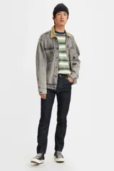 Jean de corte skinny, color azul oscuro, con tiro medio y cierre frontal con botón y cremallera. Presenta un diseño de cinco bolsillos clásico.