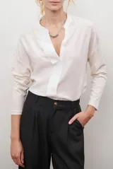 Blusa de color azul oscuro, con cuello mao y escote en V. Presenta mangas largas con puños abotonados y un corte recto y holgado.