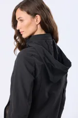 Campera de neopreno color negro, con cuello alto que incorpora una capucha oculta, cierre frontal con solapa, bolsillos laterales funcionales y corte entallado.