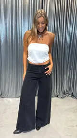 Pantalón de jean negro de corte wide leg, con costuras frontales verticales y diseño de tiro medio.