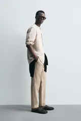 Camisa negra de lino y algodón, corte relaxed fit, cuello mao, manga larga con puños abotonados y cierre frontal con botones.