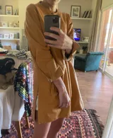 Tapado camel de cuero ovino con cuello clásico, cierre frontal con botones, bolsillos laterales y corte a la rodilla. Diseño slouchy y cómodo.