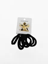 Set de accesorios para el pelo compuesto por una hebilla dorada en forma de flor y colets elásticos negros.