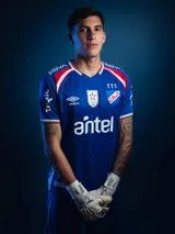 Camiseta de arquero Umbro del Club Nacional de Football, temporada 2026. Diseño en color azul con detalles en rojo y blanco en los hombros, cuello en V y estampado sutil en la tela. Incluye logo de Umbro, escudo del club, logo de la AUF y sponsor Antel en el frente.