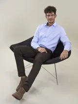 Pantalón de vestir azul marino, de corte recto, con bolsillos laterales y traseros. Se ajusta a la cintura con cinturón de cuero marrón.