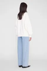Buzo oversize blanco de algodón, con cuello redondo, mangas largas con hombros caídos y estampado gráfico collegiate en el pecho.