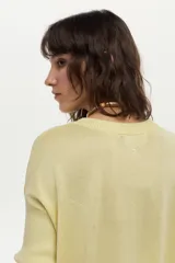 Sweater de punto con escote en V y mangas cortas, confeccionado con hilo metalizado con lurex, de calce cómodo y holgado.