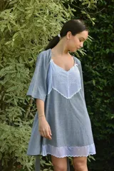 Camisón de algodón color beige con escote en V y ruedo decorados con puntilla gris. Presenta breteles finos y corte recto.