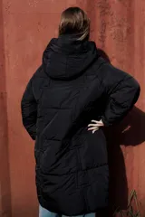 Campera larga acolchonada color marrón, con diseño midi, capucha amplia, cierre frontal con cremallera y broches, y bolsillos delanteros con tapa.