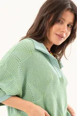 Buzo de punto color verde menta, con cuello polo y escote en V, mangas cortas y diseño holgado.