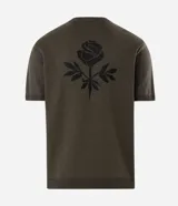 Remera de punto de algodón con textura jacquard, color verde oliva, de corte regular, cuello redondo y manga corta. Presenta un bordado de rosa en el frente.
