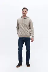 Canguro con capucha de algodón color beige, con cordones de ajuste y estampa circular frontal con el nombre de la marca y el año 1971.