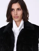 Chaleco negro de piel sintética con diseño de trenzas y cuello tipo camisa.