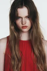 Vestido midi de color rojo confeccionado en tejido de nylon. Presenta un diseño sin mangas con cuello redondo y detalles de frunces horizontales con lazadas laterales ajustables. Cuenta con un cierre en la espalda mediante abertura y botón.