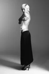 Top blanco de cuello halter y hombros descubiertos, con detalle de lazos en el delantero y cierre en la espalda con tira ajustable.