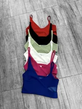 Top corto negro brillante con breteles finos y escote en V.