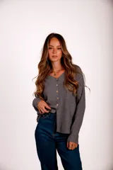 Blusa gris de morley elastizado con botones frontales y mangas largas.