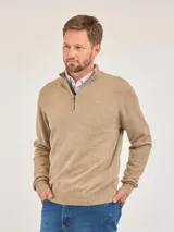 Buzo de punto color beige con medio cierre frontal, cuello alto y puños acanalados. Presenta un diseño clásico con textura acanalada en los laterales.