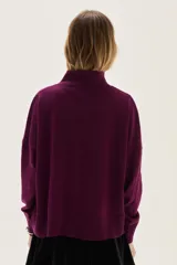 Polera de tejido de punto color azul, con cuello alto, manga larga y puños acanalados.