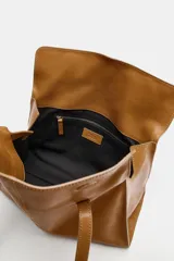 Bolso de hombro de piel color tostado, con detalle de costuras verticales pespunteadas en el cuerpo, doble asa de hombro y cierre con botones imantados.
