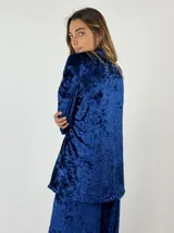 Blazer gris de terciopelo con solapas y cierre frontal con un botón. Presenta un patrón de matices sutiles en la tela.