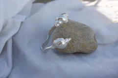 Brazalete rígido abierto de plata 925 con terminales en forma de caracolas.