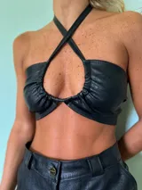 Top halter negro con textura croco y tiras cruzadas en el cuello.