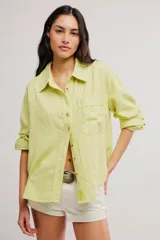 Blusa de lino y viscosa color verde lima, de corte relajado, con cuello camisero, cierre frontal de botones, bolsillo aplicado en el pecho y mangas largas remangables.