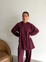 Canguro de tejido acanalado color bordó, con capucha, mangas largas abullonadas y corte holgado.