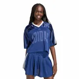 Remera deportiva Adidas W Sta Seas Tee de color azul marino, con diseño corto y estilo tipo camiseta de fútbol. Cuenta con cuello en V blanco y beige, mangas cortas con franjas blancas en los hombros, y gran estampado frontal con la marca Adidas.