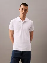Chomba blanca de corte regular, con cuello clásico y tapeta de dos botones. Presenta un pequeño monograma bordado en el pecho. Confeccionada en poliéster reciclado de secado rápido.