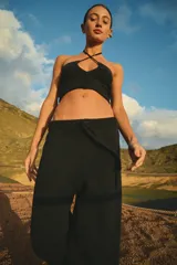 Pantalón tejido en algodón color negro, con cintura ancha en rib con elástico interno y tiras regulables. Diseño moderno y fluido.