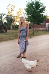 Vestido strapless de jersey elastizado color gris, con fruncido en los laterales del cuerpo y falda larga de gasa con caída.