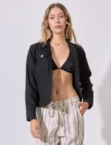 Camisa tipo campera de lino marca Dash, color blanco, con cierre frontal de botones, cuello camisero y bolsillos con solapa en el pecho.