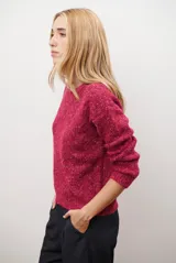 Buzo de punto con cuello redondo, manga larga y textura jaspeada en tonos beige y crema.